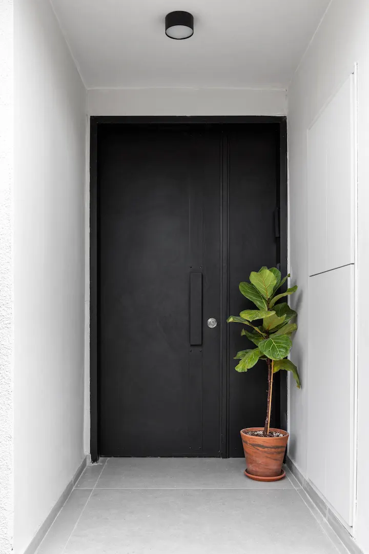 Black door at the end of an entrance hall