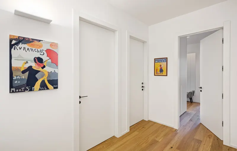 White interior doors in a wooden floored hallway