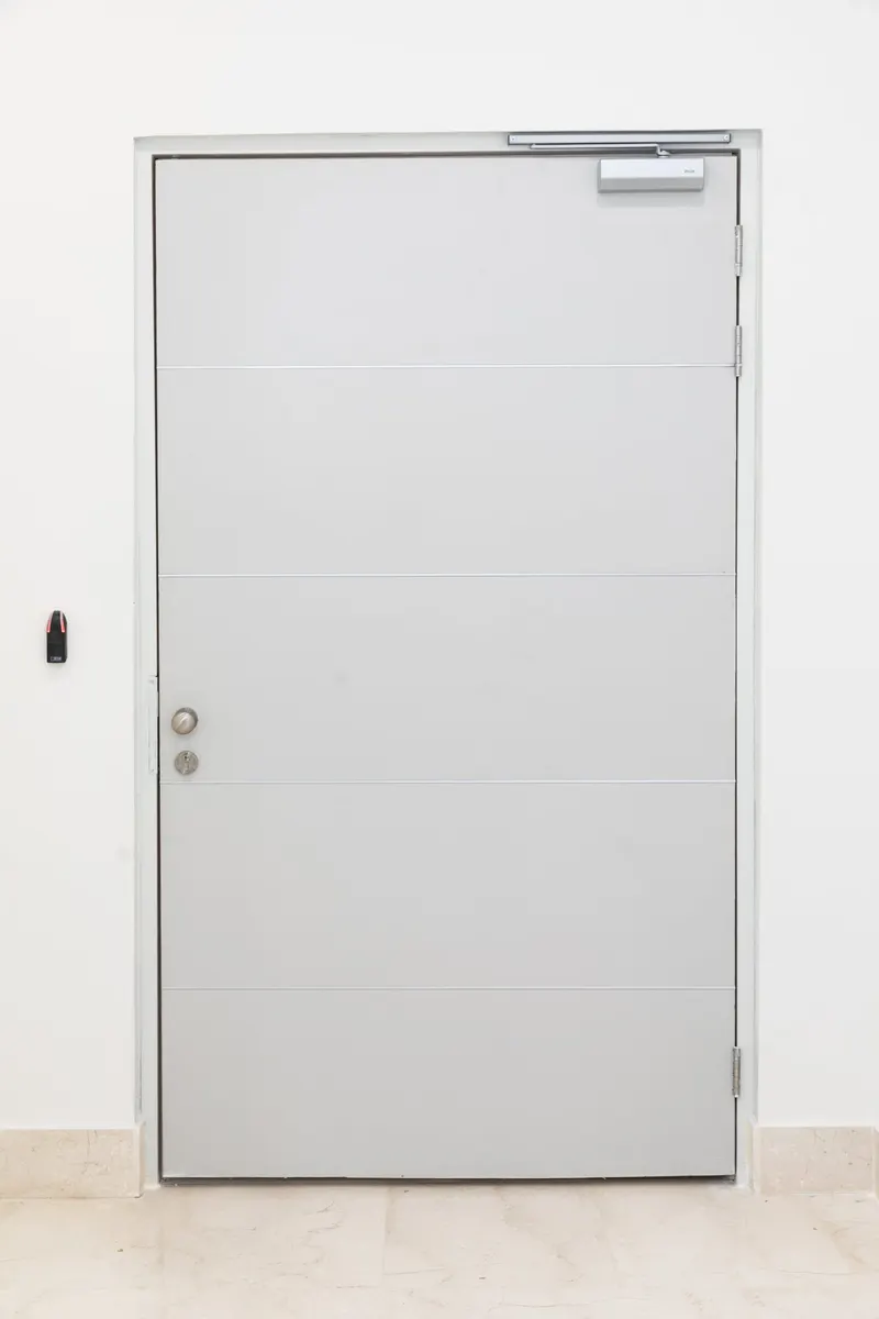 Plain white steel door in a white room